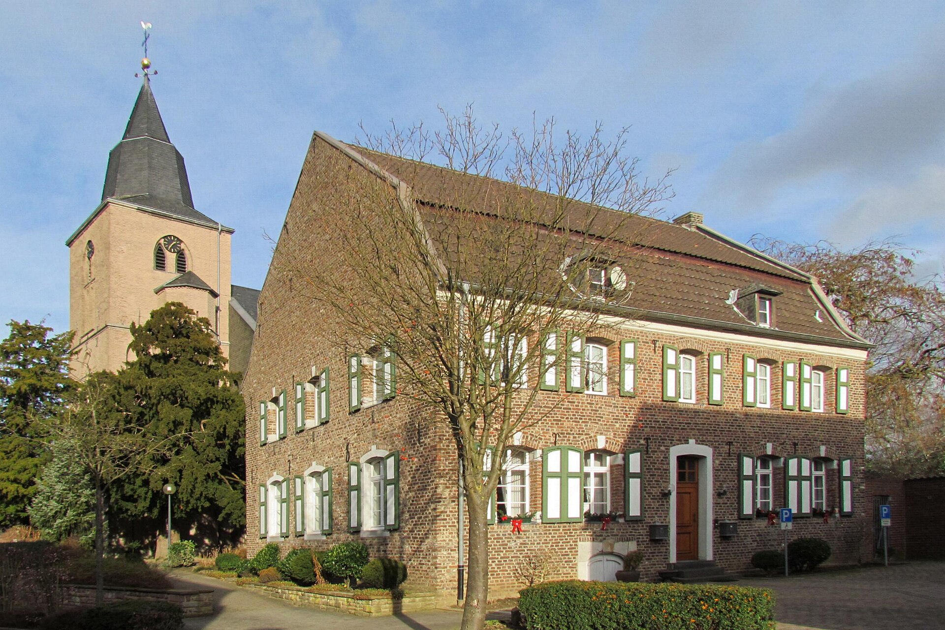 Die Kirche St. Willibrord mit Pfarrhaus in Teveren